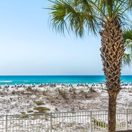 Palm trees frame stunning white sand and turquoise Gulf waters just beyond the property, offering a pristine beach setting for your coastal retreat.