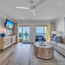 Relax in your oceanfront living room with coastal blues, comfortable seating, and stunning sea views from your private balcony.