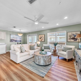 Welcome to Sunset Cottages 2C - Melrose Place! Relax in your coastal-themed living space with plush seating, ceiling fan, and a fully equipped kitchen for memorable meals together.