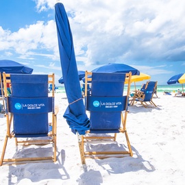 Pristine beach setting with branded chairs and umbrellas, perfect for soaking up the Florida sunshine.