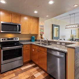 Your fully equipped kitchen features granite counters, stainless appliances, and opens to ocean views—perfect for your morning coffee routine.