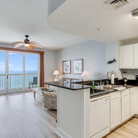 Your open-concept kitchen flows seamlessly into the living area, where stunning ocean views through floor-to-ceiling windows create the perfect backdrop for your getaway.