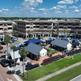 Multi-story vacation resort buildings with modern amenities and recreational facilities surrounded by palm trees and green spaces.