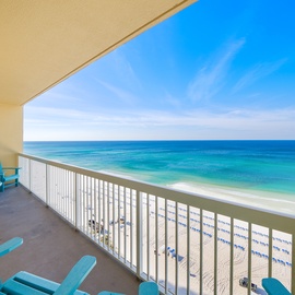 Relax on your private balcony with turquoise ocean views and watch beachgoers below from your comfortable seating.