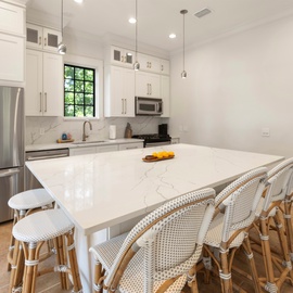 You'll love cooking in this stunning white kitchen with marble countertops and spacious island seating for memorable meals together.