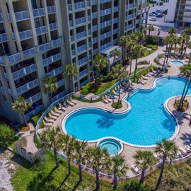 Stunning beachfront resort with expansive freeform pool, palm trees, and direct beach access for the perfect coastal getaway.