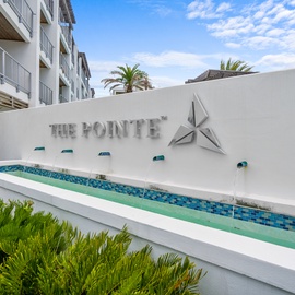A sophisticated welcome awaits at The Pointe, where modern design meets tropical elegance in this beautifully landscaped entrance.
