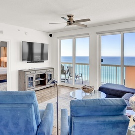 Relax in your bright living room where turquoise waters stretch endlessly beyond floor-to-ceiling windows, creating the perfect oceanfront retreat.