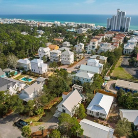 Aerial view showcasing the coastal community with charming beach homes nestled among trees, just minutes from pristine Gulf waters.