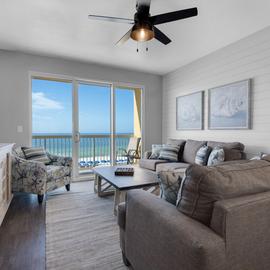 Your bright living space opens to stunning ocean views through floor-to-ceiling windows, where plush seating invites relaxation.