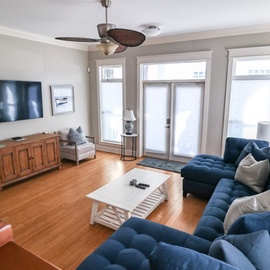 Sink into your plush blue sectional and enjoy movie nights on the wall-mounted TV in this bright, welcoming living room.