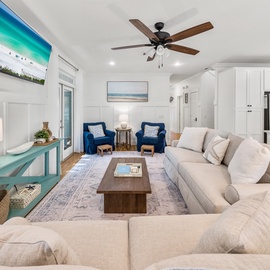 Sink into plush sofas in your open-concept living space, where coastal blues and whites create a serene atmosphere perfect for relaxing.