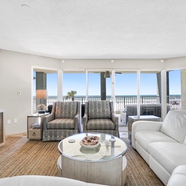 Your spacious living room opens to stunning ocean views through floor-to-ceiling windows, creating the perfect seaside retreat.