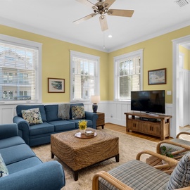 Sink into the plush blue sectional and let the ceiling fan keep you cool while you enjoy movie nights in your sunny yellow living room.