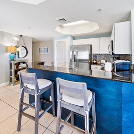 Your modern kitchen features a stunning blue island with granite countertops, perfect for morning coffee or casual meals together.
