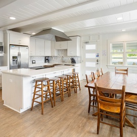 Your spacious kitchen flows seamlessly into the dining area, perfect for cooking family meals and gathering around the warm wood table.