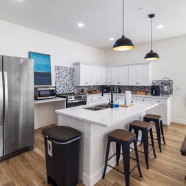 Your modern, fully equipped kitchen invites you to prepare meals together with its spacious island, stainless steel appliances, and bright, airy atmosphere that makes cooking feel effortless.