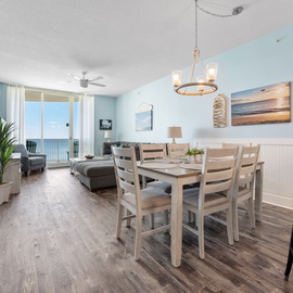 Your coastal haven features an open dining and living space with stunning sea views through floor-to-ceiling windows, perfect for memorable meals.
