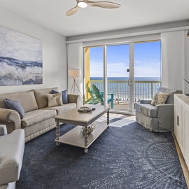 Sink into plush seating while enjoying stunning ocean views through floor-to-ceiling windows in your bright, coastal-inspired living space.