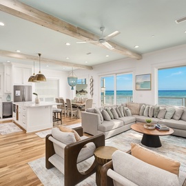Relax in your stunning open-concept living space where ocean views stretch endlessly through floor-to-ceiling windows while you unwind on plush seating.