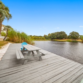 Your private waterfront deck awaits with picnic seating overlooking tranquil waters, swaying palms, and endless blue skies.