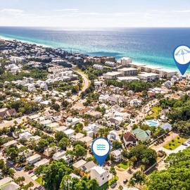 Aerial perspective of a scenic coastal community nestled between lush greenery and pristine turquoise waters, offering the perfect beachside escape.