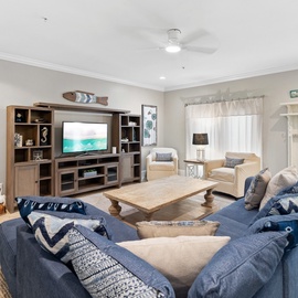 Settle into your coastal-inspired living room, where plush blue sofas and beachy decor create the perfect backdrop for movie nights and lazy afternoons with your travel crew.