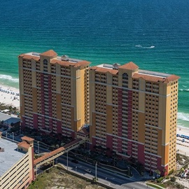 Beachfront property towers rise majestically along pristine turquoise waters, offering stunning coastal views and direct beach access.
