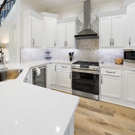 You'll love creating culinary masterpieces in this stunning chef's kitchen, featuring pristine white cabinetry, marble countertops, and premium stainless steel appliances.