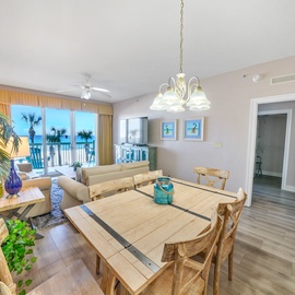 Gather around your spacious dining table while enjoying stunning ocean views through floor-to-ceiling windows in this bright, coastal-inspired living space.