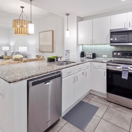 Step into your fully equipped kitchen featuring granite countertops, stainless steel appliances, and an open layout perfect for preparing meals together.