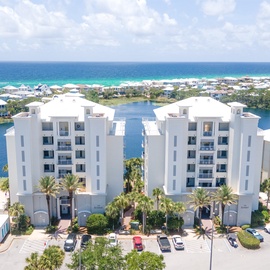 Modern white resort buildings positioned between sparkling lagoon waters and pristine Gulf Coast beaches.