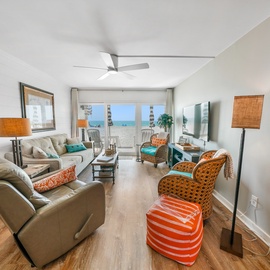 Sink into plush seating while ocean breezes flow through your bright living space, where coastal colors and stunning sea views create your perfect beach retreat.