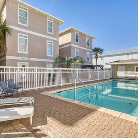 Private pool area with comfortable loungers for sunny days in this beachside vacation rental community.