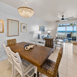Gather around your elegant dining table, where golden chandeliers cast warm light as ocean views frame every meal through expansive windows.