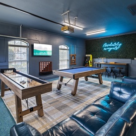 Step into your ultimate game room where friendly competition awaits with pool tables, arcade games, and cozy leather seating.