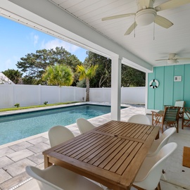 Your private poolside retreat awaits with comfortable loungers and shaded dining under swaying palms.