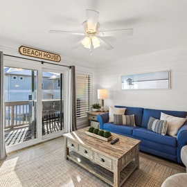 Your coastal retreat awaits with plush blue seating, nautical touches, and sliding doors that open to your private balcony with beach views.
