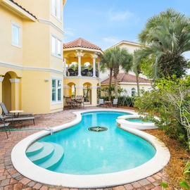 Your private oasis awaits with a sparkling pool surrounded by tropical palms and elegant Mediterranean architecture.