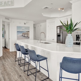 Your coastal-inspired kitchen awaits with marble countertops and ocean views, perfect for preparing meals while soaking in beach vibes.