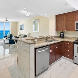 Your fully equipped kitchen opens to the living area with stunning ocean views through floor-to-ceiling windows.