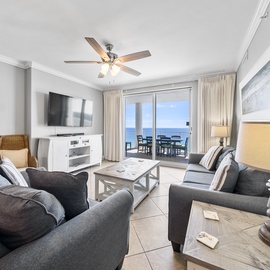 Relax in your bright living space with plush seating and stunning ocean views through the balcony doors.
