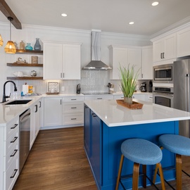 Your gourmet kitchen features a vibrant blue island, perfect for morning coffee or evening gatherings.