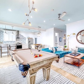 Your stylish retreat features a sleek pool table perfect for friendly competition, flowing seamlessly into the modern kitchen and cozy living space.