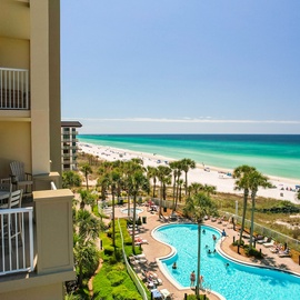Modern beachfront property showcases stunning Gulf Coast waters and pristine white sand beaches with tropical landscaping and resort amenities.