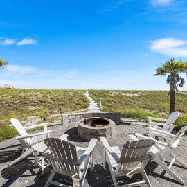Gather around your private fire pit on this stunning deck, surrounded by swaying palms and coastal dunes under endless blue skies.