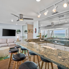 Relax in your open-concept living space where granite countertops meet coastal comfort, perfect for morning coffee or evening conversations.