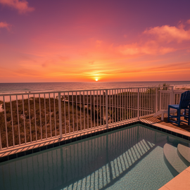 Stunning beachfront balcony featuring a private pool overlooking golden sunset views across pristine coastline.