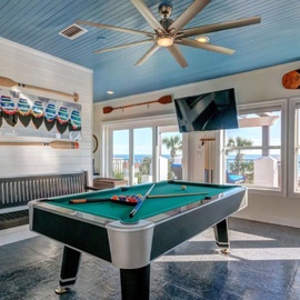 Challenge friends to pool while enjoying ocean views through floor-to-ceiling windows in your private game room.