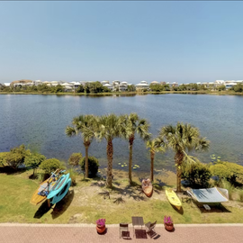 Serene lakefront setting with palm trees and kayaks ready for exploration in this peaceful residential community.